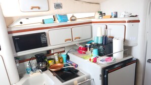 A compact kitchenette with a sink, stove, and storage cabinets. - YACHT 33'~FREE KAYAK  (Key Largo)