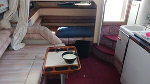 A compact RV interior with a kitchenette, a small table with a bowl, and a blue cushion. - YACHT 33'~FREE KAYAK  (Key Largo)