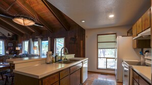 A spacious kitchen with wooden cabinets, a large island, and a built-in dishwasher.
