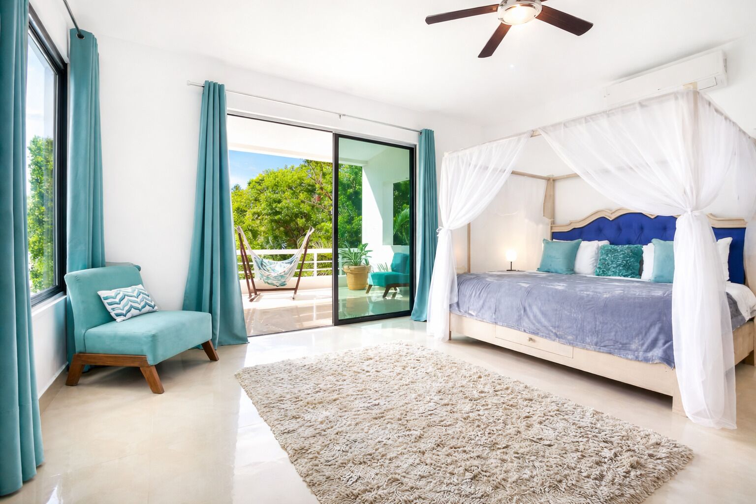 A bedroom with a bed, a chair, and a view of the outdoors.