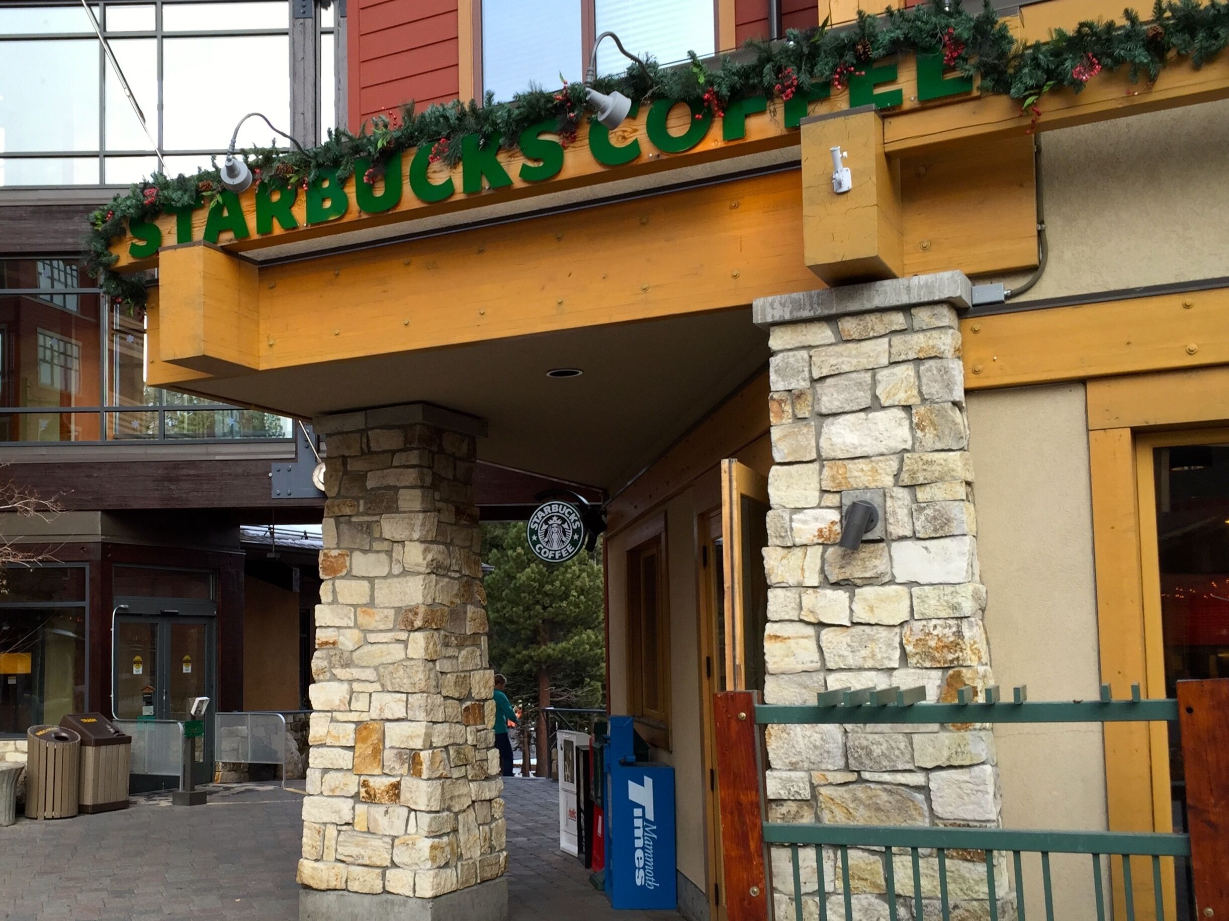 Ein Starbucks Coffee Geschäft mit einer Stein-Fassade und einem hölzernen Vordach.