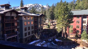 A multi-story building with balconies, a ski slope, and a mountainous backdrop. - Village Top Floor Lincoln House - Great 2 Bedroom With View of Mammoth Mountain  (Mammoth Lakes)