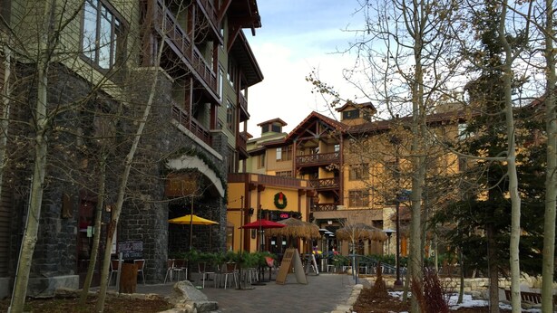 A multi-story building with a stone facade, outdoor seating area, and a central staircase. - Village Top Floor Lincoln House - Great 2 Bedroom With View of Mammoth Mountain  (Mammoth Lakes)