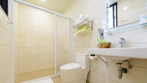 Un baño moderno con inodoro, lavabo y zona de ducha.