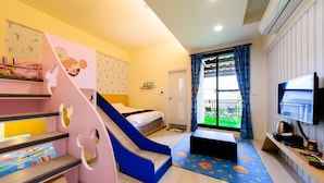 Una habitación infantil con una escalera rosa, un tobogán azul, una cama, un televisor y una ventana con vistas al exterior.
