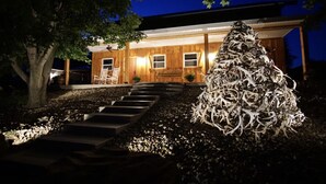 A modern house with a wooden exterior, a porch with chairs, and a large tree in front. - Cabin and Private Basketball Gym, Hocking Hills (Logan)