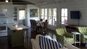 Un amplio salón con cocina, mesa de comedor y asientos.
