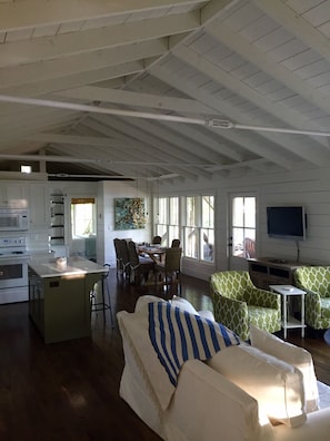 A spacious living area with a kitchen, dining table, and seating.