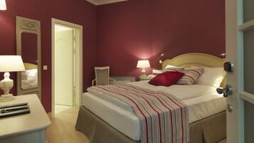 Un dormitorio ordenado con cama, mesitas de noche y mesilla.