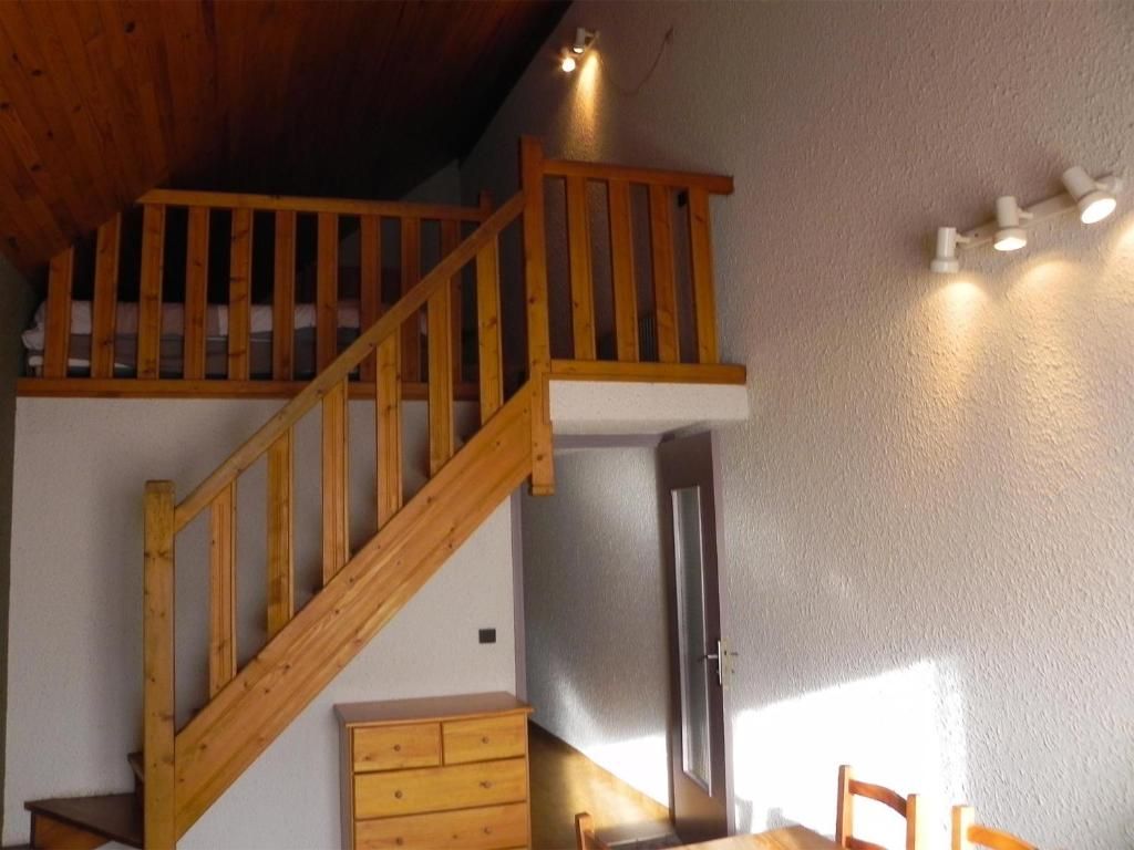 Eine Holztreppe führt zu einem Erkerbereich mit einer weißen Wand und einer Tür.