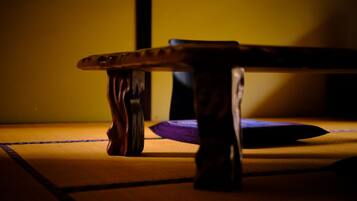Ein Holztisch mit Kissen auf einem Tatami-Boden.