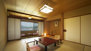 Una habitación japonesa tradicional con suelo de tatami, una mesa baja y puertas correderas.