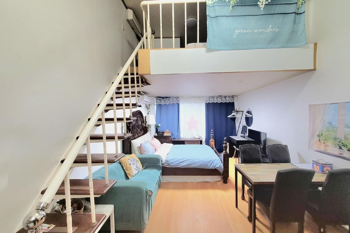 Une chambre de style loft avec un lit superposé, un bureau et une chaise.