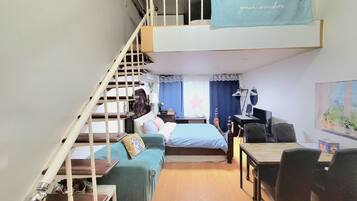 Une chambre de style loft avec un lit superposé, un bureau et une chaise.