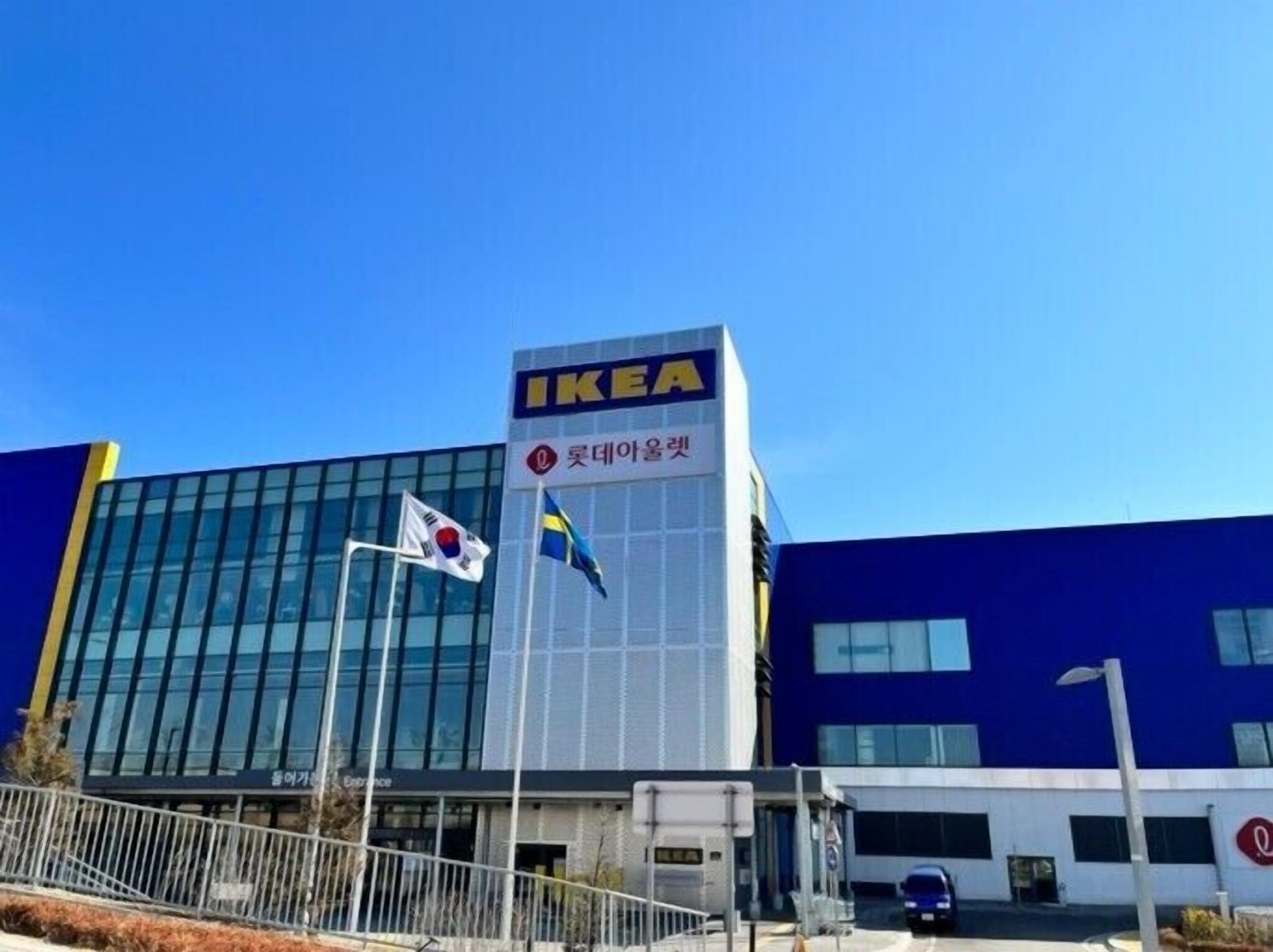 Un edificio moderno con un llamativo letrero de IKEA, que presenta la bandera sueca y texto en coreano.