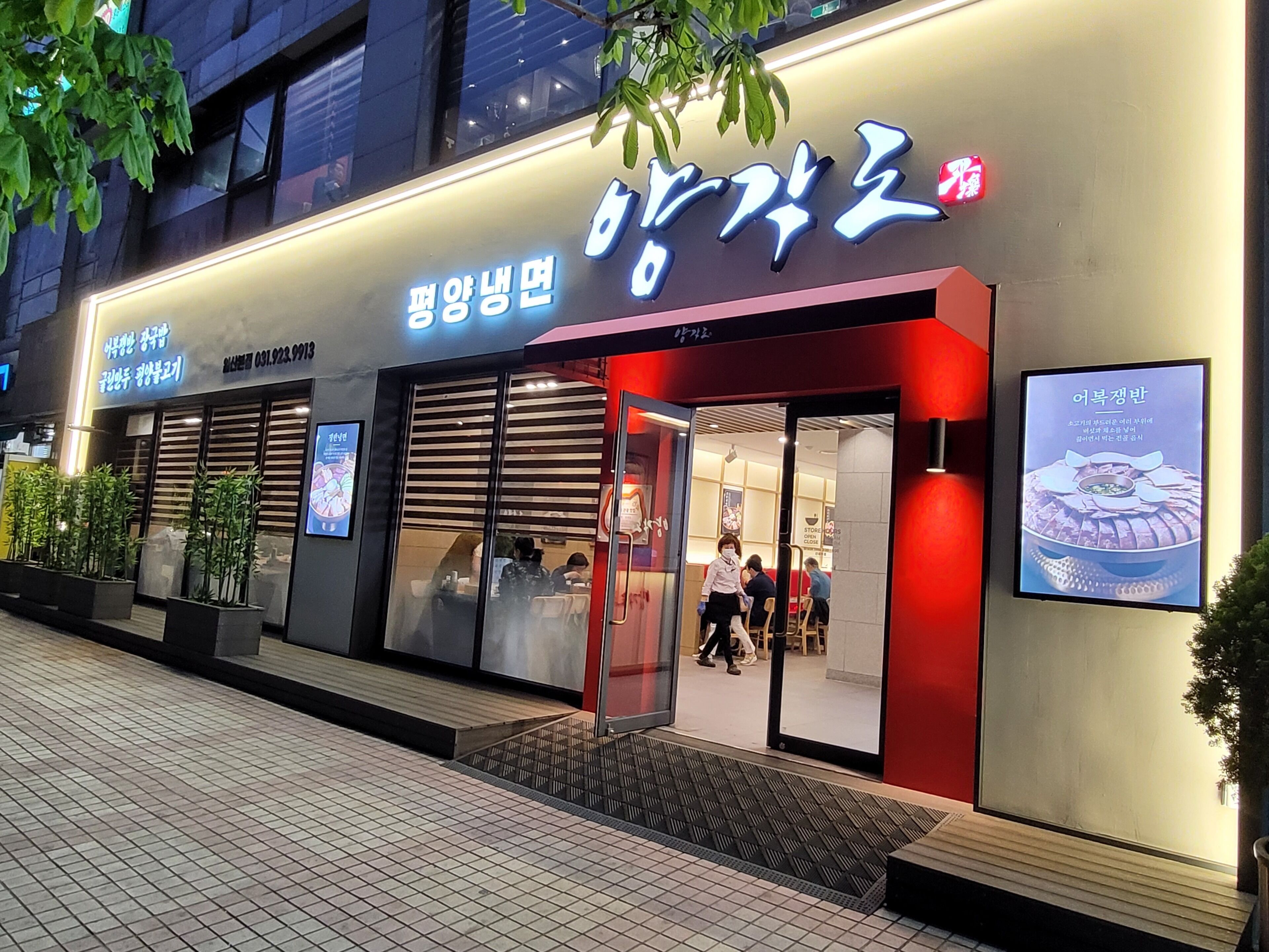 A restaurant with a modern facade, illuminated signage, and a visible entrance.