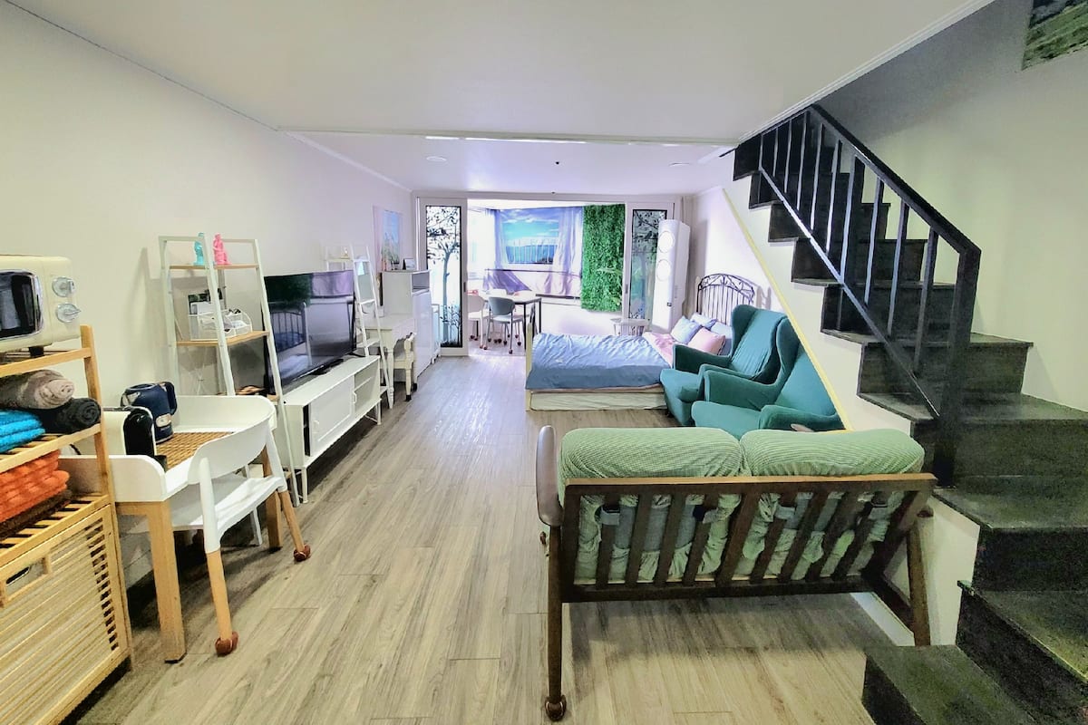 Un appartement moderne comprenant un salon, un coin repas et un escalier.