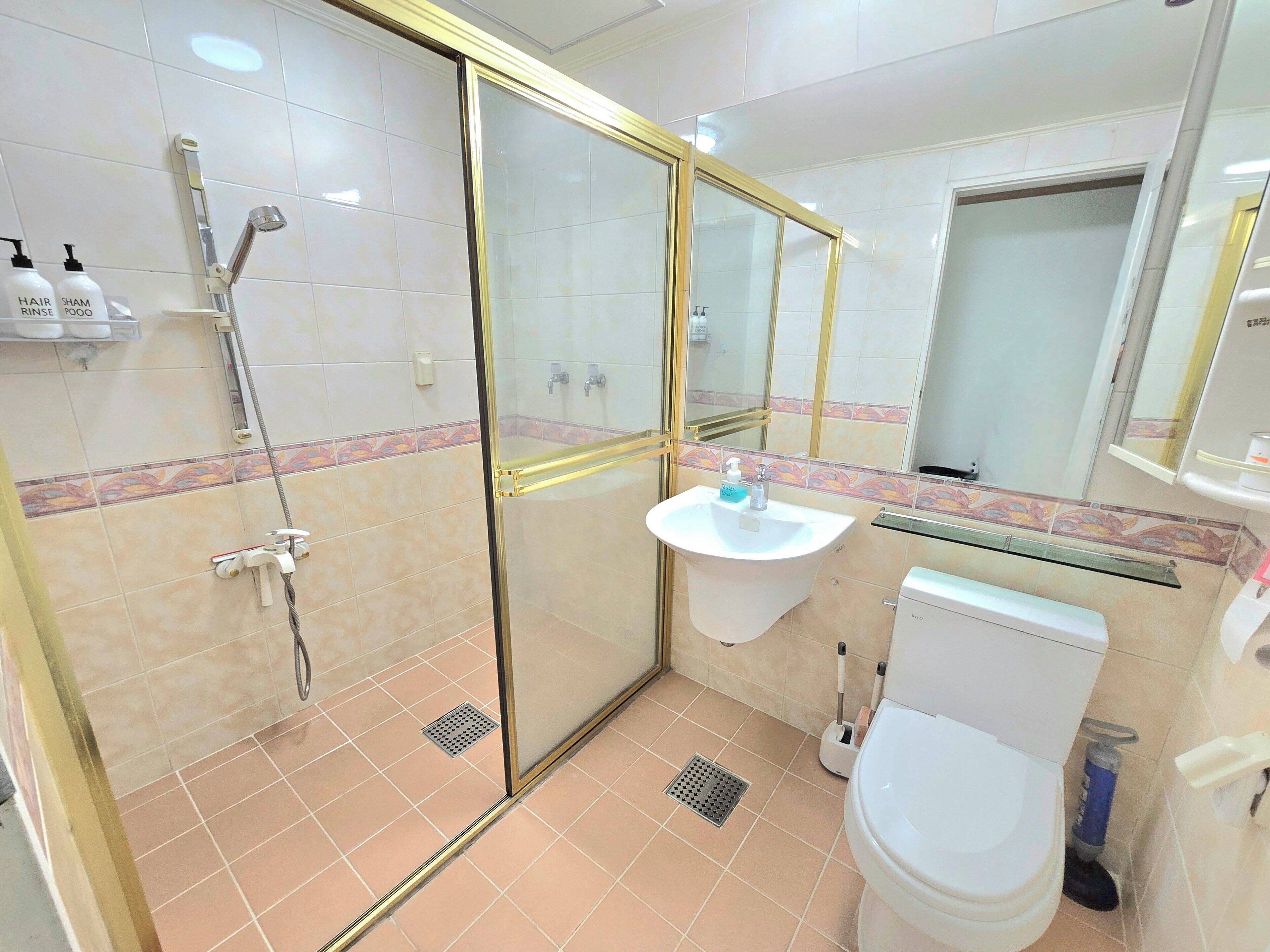 Ein Badezimmer mit Duschkabine, Waschbecken und Toilette.
