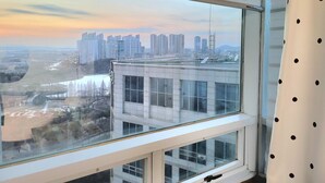 Vista desde una ventana con vistas a un paisaje urbano, incluyendo rascacielos y un río.