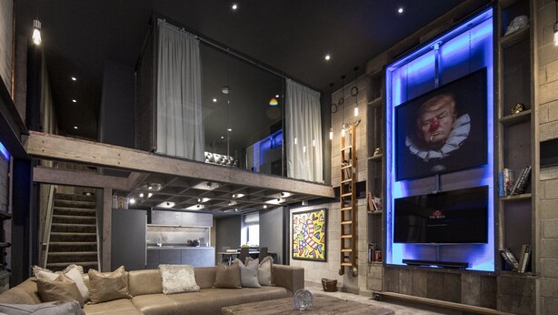 A modern living room with a large sectional sofa, a wooden coffee table, and a flat-screen TV mounted on a wall. - The Bells (Leeds)