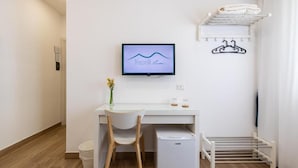 A modern, minimalistic room with a desk, chair, and a television displaying 'Napoli Live'. - Napolilive (Naples)