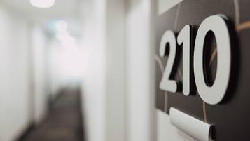 A close-up of a wall-mounted sign with the number "210" in a modern, minimalist design.