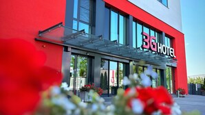 A modern hotel building with a red and grey facade, large windows, and a visible entrance. - 3G Hotel (Fulda)
