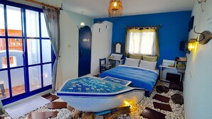 Un dormitorio con cama, ventana y mesita de noche.
