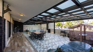 An outdoor patio with a pool, a dining area, and a seating area with a canopy.
