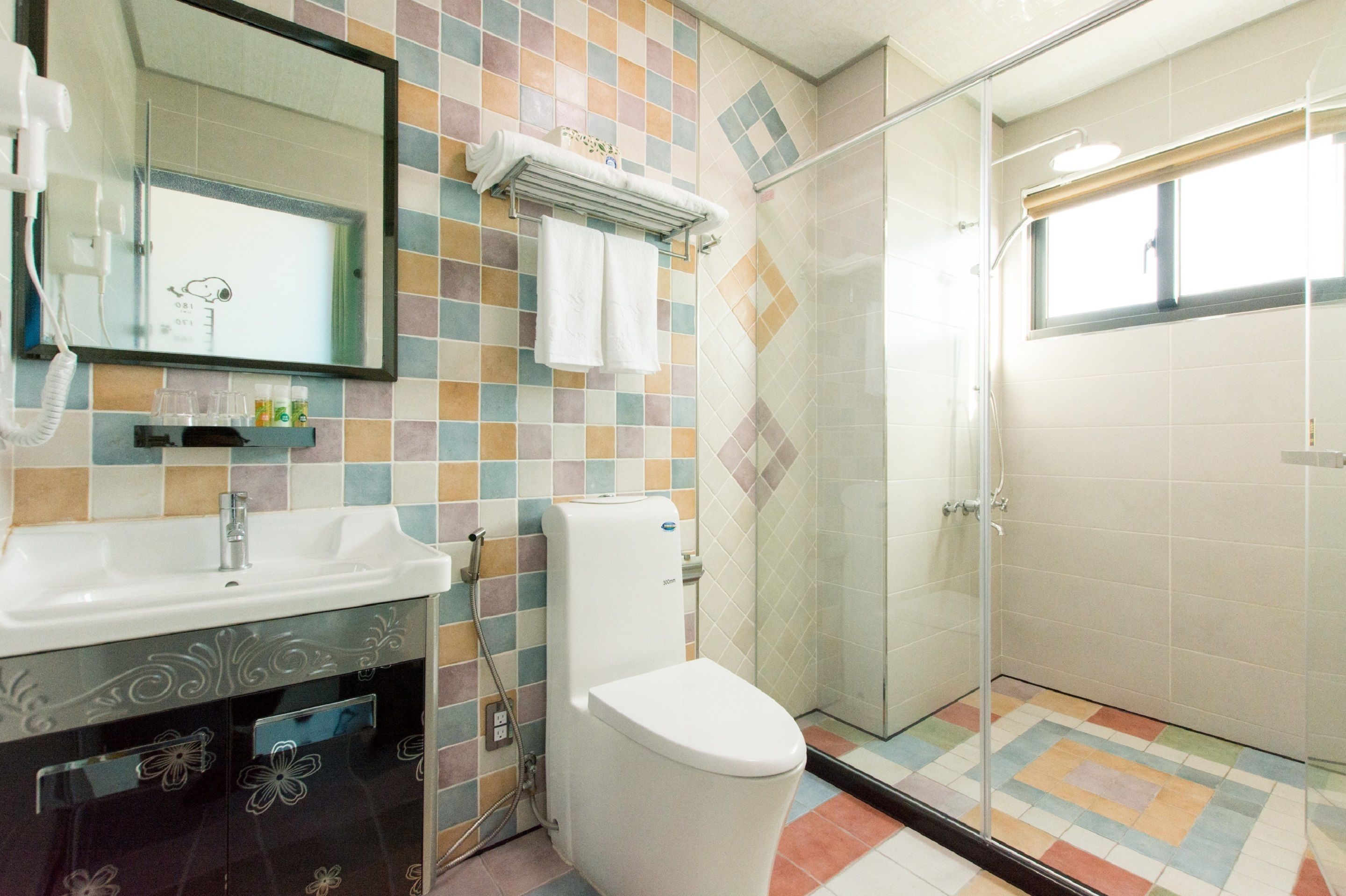 Une salle de bain avec un sol carrelé, un lavabo, des toilettes et un espace douche.