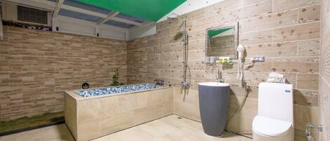 A modern bathroom with a large bathtub, a toilet, and a sink.