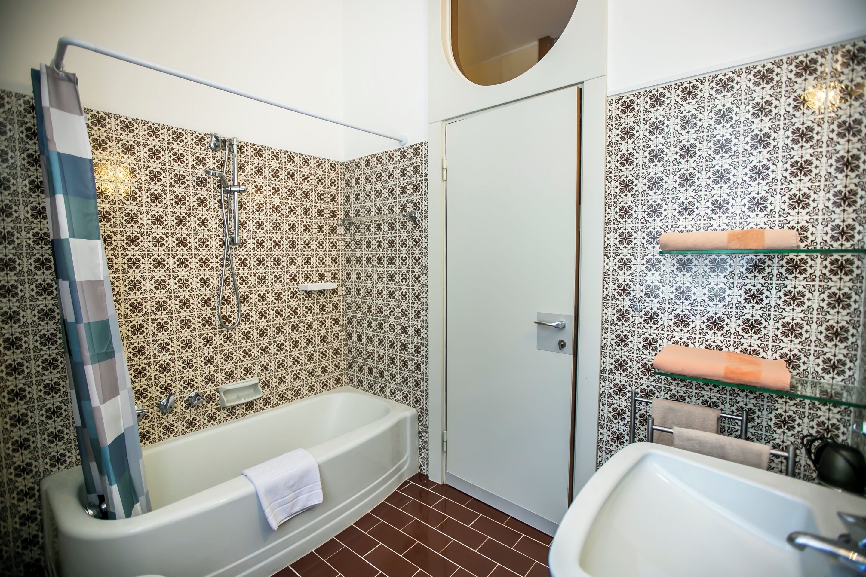 A bathroom with a bathtub, a sink, and a shower area.