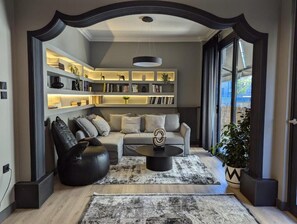 A modern living room with a sofa, coffee table, and bookshelf. - Be My Guest Athens (Athens)