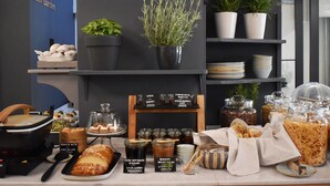 A buffet setup with various food items, including bread, preserves, and jars of honey and jam. - Be My Guest Athens (Athens)