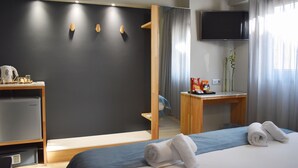 A modern hotel room with a bed, a desk, a television, and a mirror. - Be My Guest Athens (Athens)