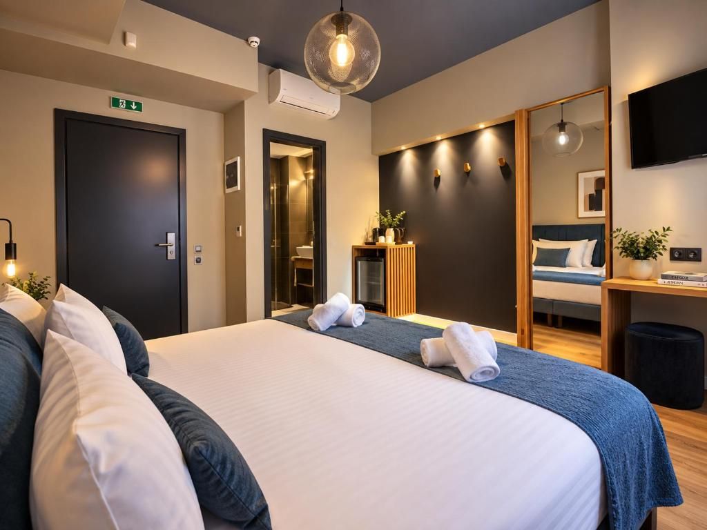 A hotel room with a large bed, a desk, a television, and a mirror.