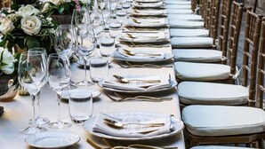 A long dining table set with plates, cutlery, and glasses, flanked by chairs. - Duchess Boutique Hotel B&B (Florence)