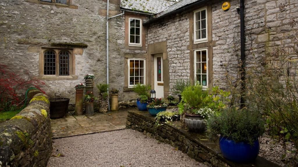 A stone building with multiple windows and a sign that reads "Yale".