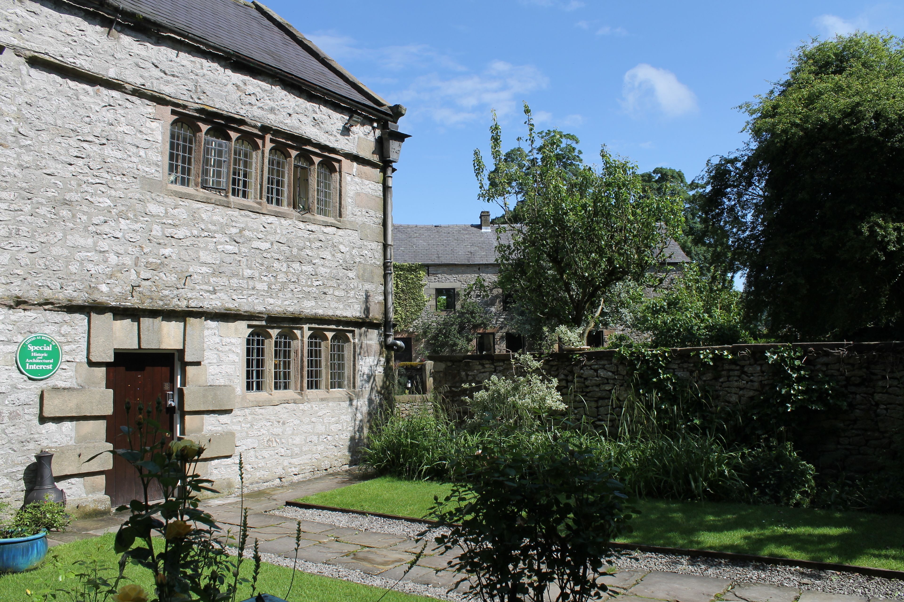 A stone building with a traditional architectural style, featuring a stone facade and a wooden door.
