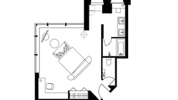 A floor plan of a hotel room with a bed, a desk, a chair, a small table, and a bathroom.