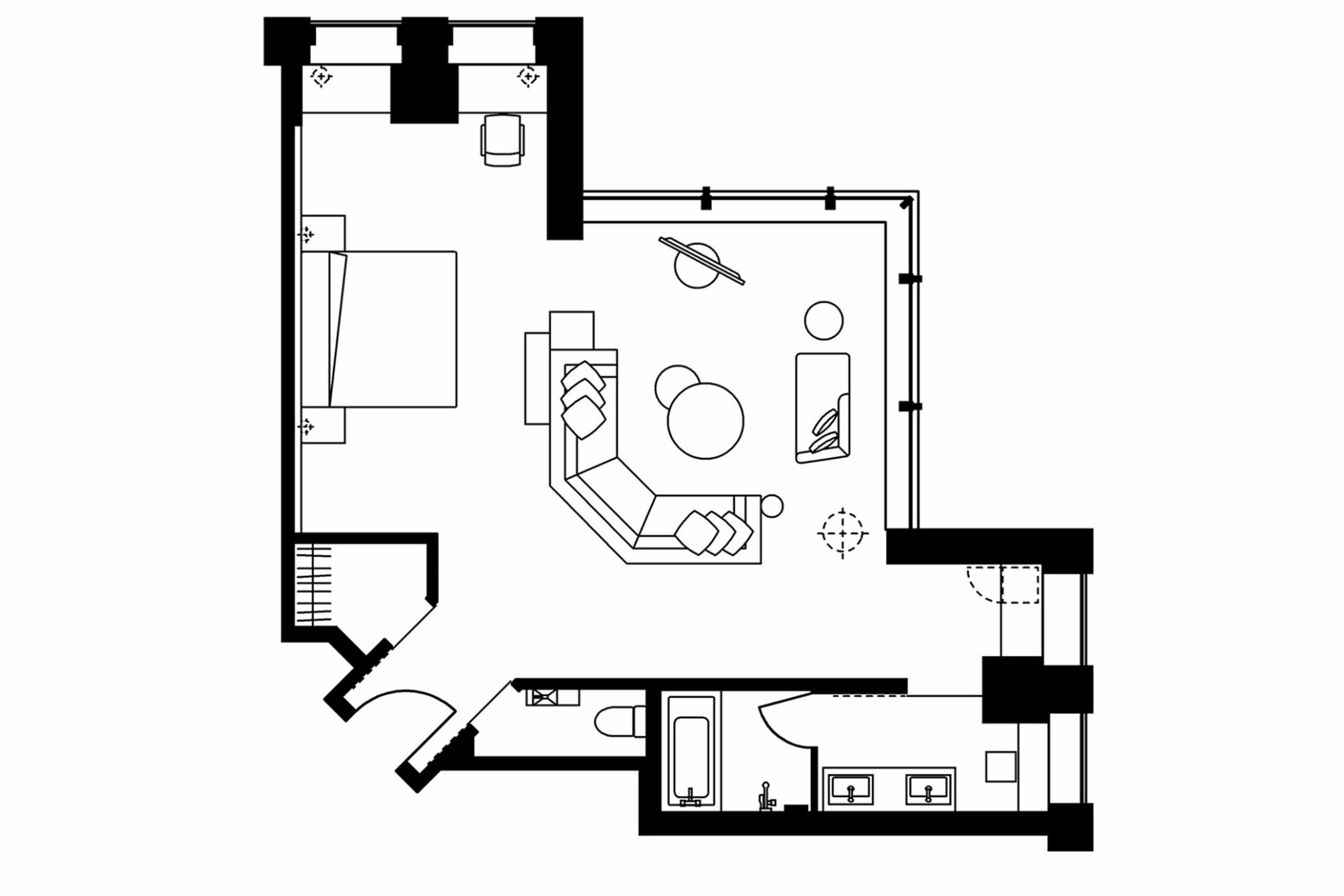 Distribución de una habitación de hotel con cama, escritorio, silla, mesita, sofá y baño.