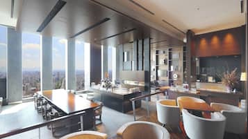 Une chambre d’hôtel moderne offrant une vue imprenable sur la ville, un espace repas spacieux et un coin salon confortable.