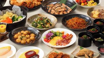 A variety of dishes on a table, including sushi, salads, and meat dishes.
