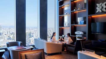 Un interior moderno con vistas a la ciudad, amplias ventanas y muebles contemporáneos.