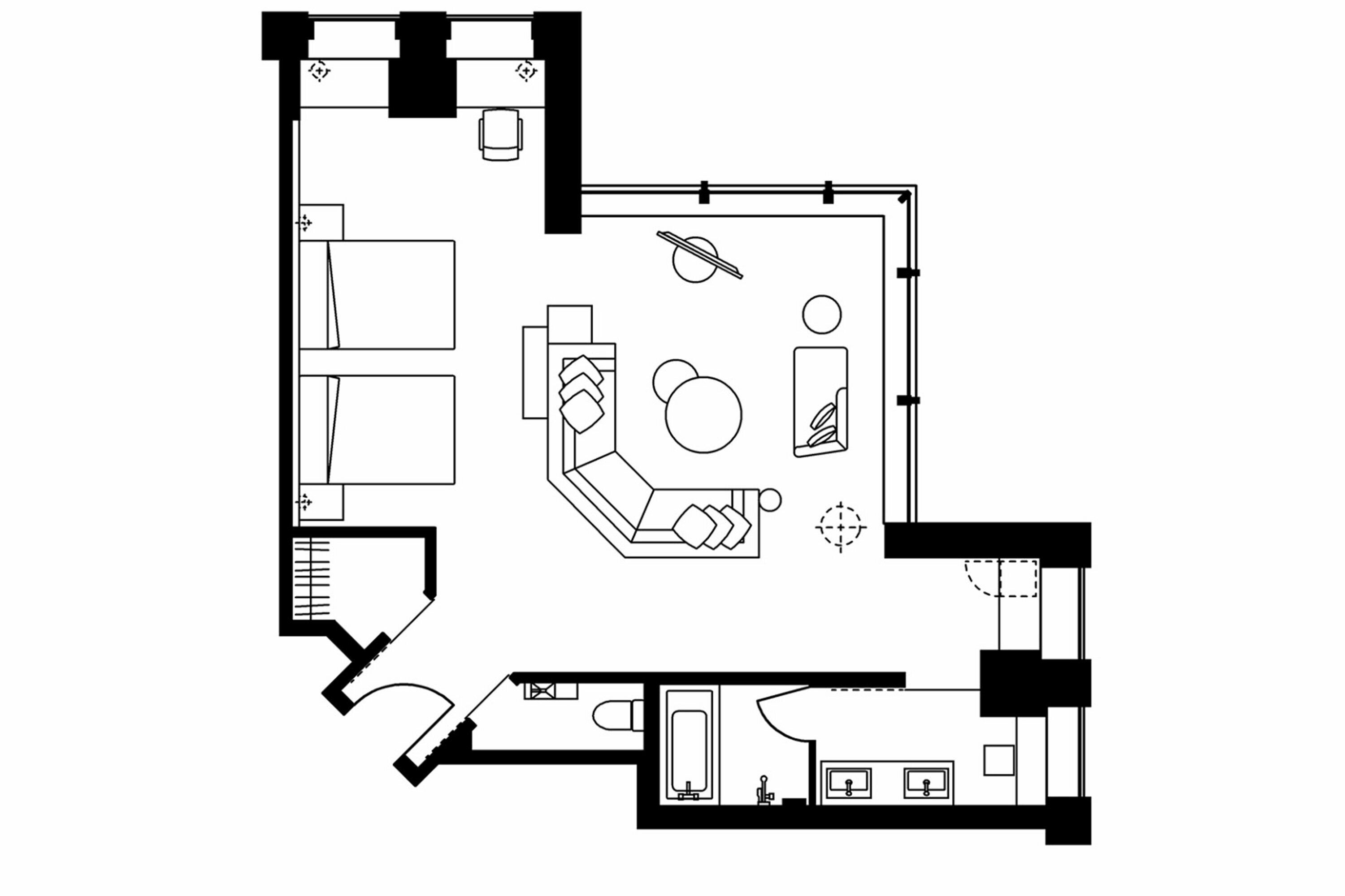 A hotel room layout with a bed, seating area, and bathroom.