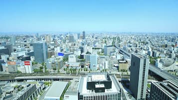 A cityscape with modern buildings, a prominent skyscraper, and a highway.