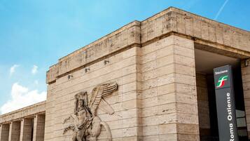 A building facade with a relief sculpture and signage for "Roma Ostiense."