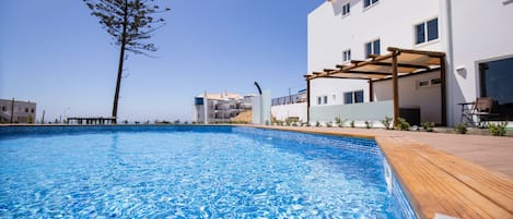 Piscine extérieure, parasols de plage, chaises longues