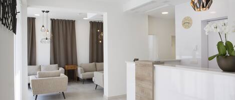 A modern living room with a sofa, a coffee table, and a dining area with a table and chairs.
