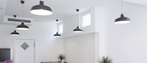 A modern dining area with black pendant lights, rectangular tables, and black chairs.